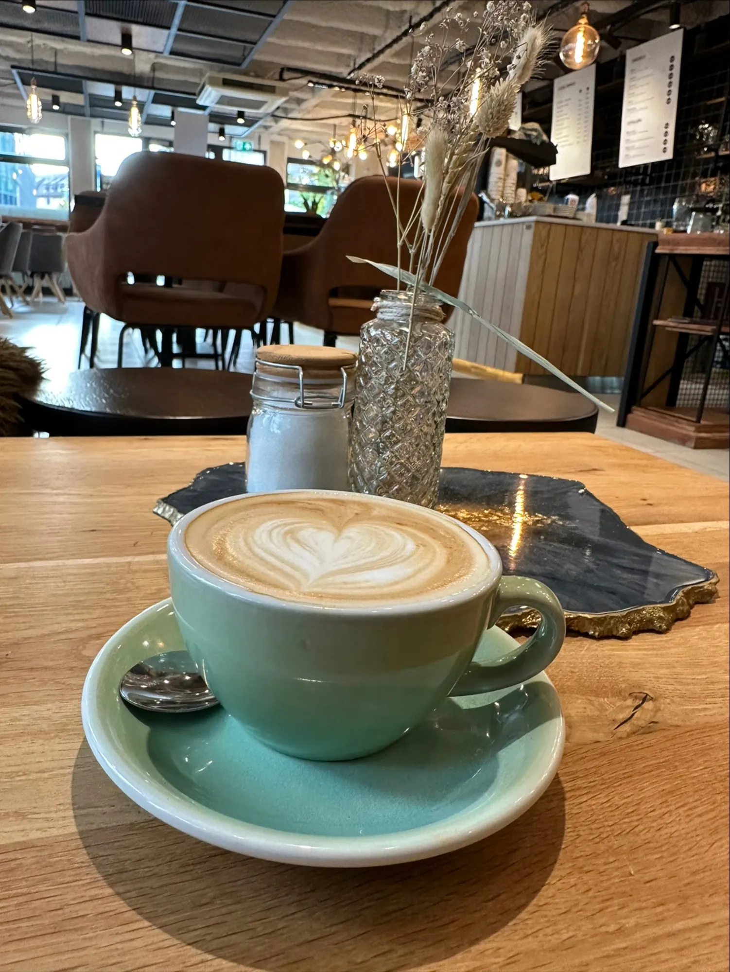 Cappuccino mit Latte Art in einer mintgrünen Tasse